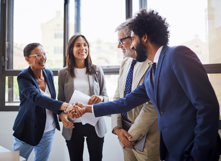 A man and woman shake hands next to another man and woman.