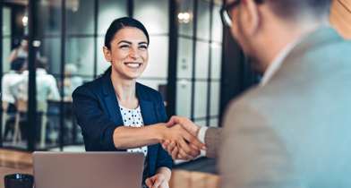 A woman shakes the hand of a man.